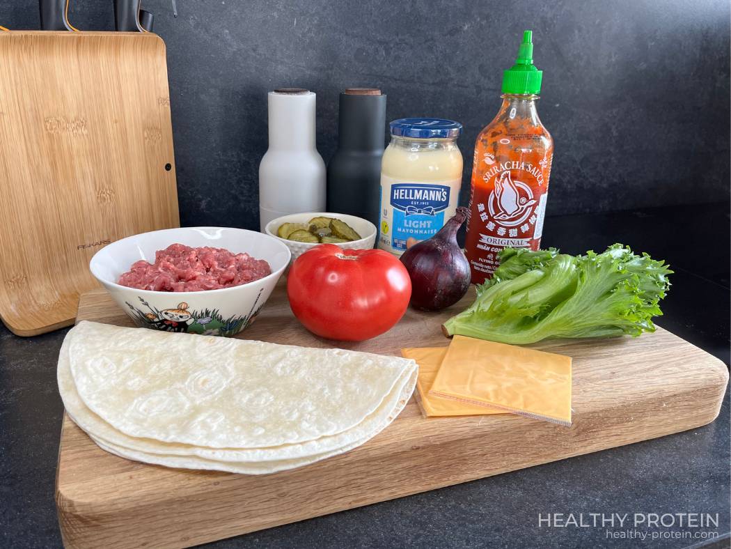 Cheeseburger wrap tortilla recipe ingredients - ground beef, cheese, tomato, lettuce, red onion, pickles, mayo, sriracha sauce - high protein meail